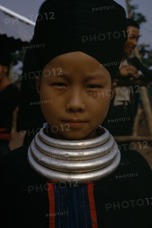 LAOS, Tribal People, Meo Tribe, Head and shoulders portrait of a Meo girl wearing traditional dress and neck rings.