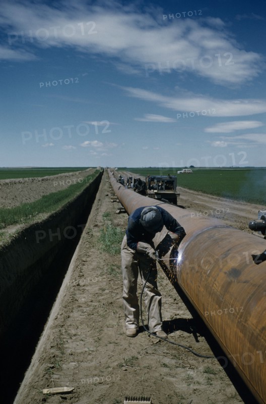 CANADA, Saskatchewan , Prairies, Constructing Trans Canada gas pipeline over Saskatchewan Prairies. A worker called Mr E Thompson welding
