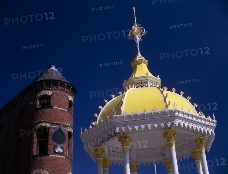 IRELAND, North, Belfast, "Victoria Square.  Detail of yellow and white canopy of the Jaffe Memorial Fountain, constructed in 1874 with top of the brick exterior facade of Bittles Bar behind."