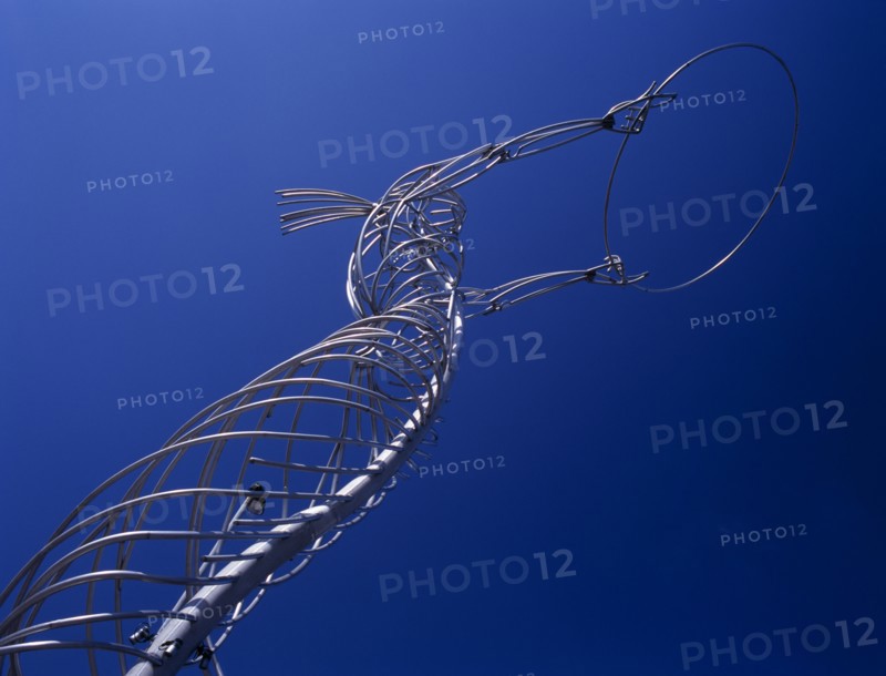 IRELAND, North, Belfast, "Oxford Street.  Angled view of modern metal sculpture from low viewpoint looking up, depicting female figure holding up hoop against cloudless blue sky."