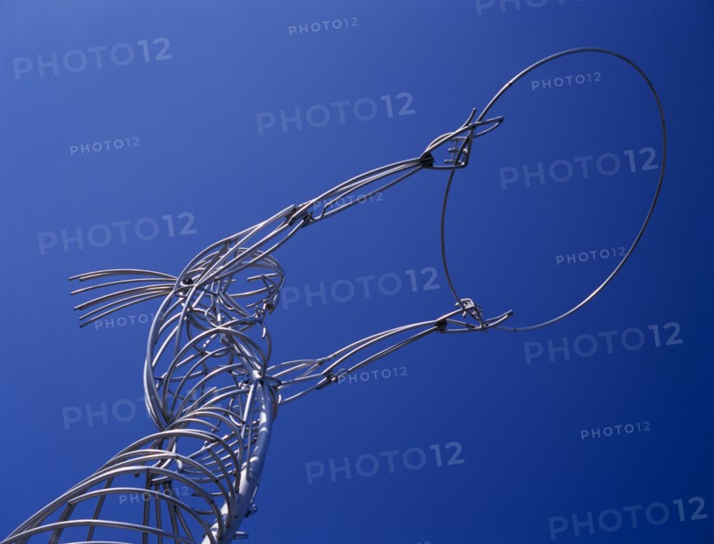 IRELAND, North, Belfast, "Oxford Street.  Angled, part view of modern metal sculpture from low viewpoint looking up, depicting female figure holding up hoop against cloudless blue sky."
