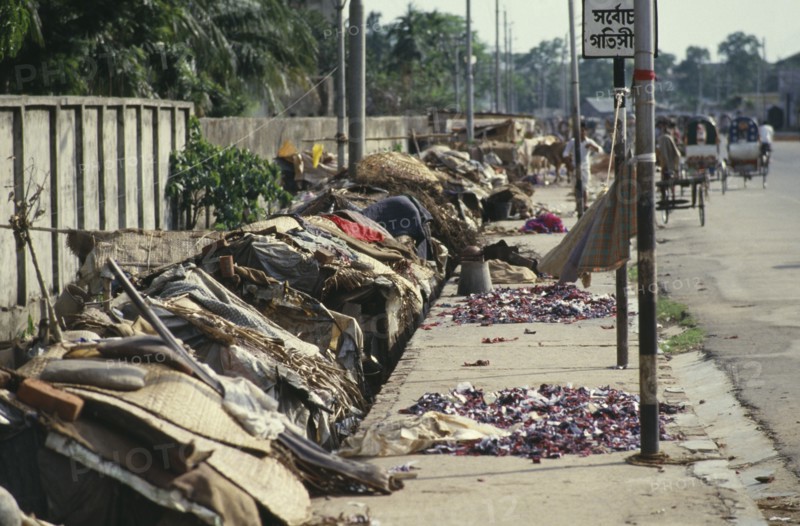 BANGLADESH, Dhaka, Roadside slum dwellings along pavement in city centre.