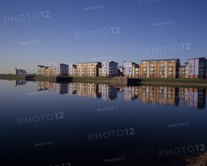 WALES, Carmarthenshire , Llanelli, Millennium Quay dockside apartments development with the buildings reflected on water.