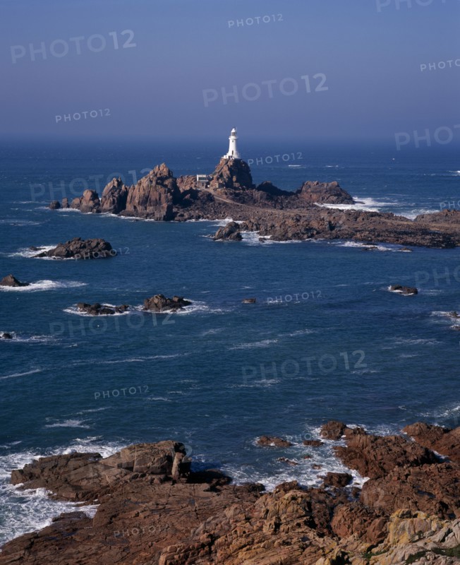 UNITED KINGDOM, Channel Islands, Jersey, St Brelade. Corbiere Lighthouse and rocky foreshore