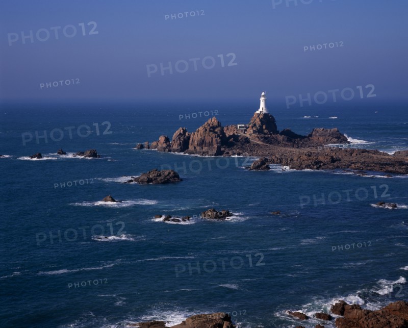 UNITED KINGDOM, Channel Islands, Jersey, St Brelade. Corbiere Lighthouse and rocky foreshore