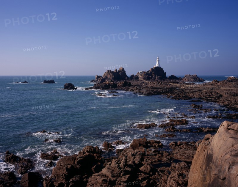 UNITED KINGDOM, Channel Islands, Jersey, St Brelade. Corbiere Lighthouse and rocky foreshore