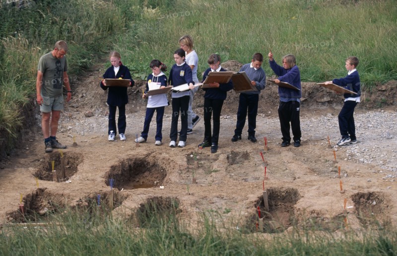 ENGLAND, Yorkshire, Whitby Abbey, Students and teacher on school field trip at archaeological dig in the graveyard at Whitby Abbey founded by St Hilda AD657.