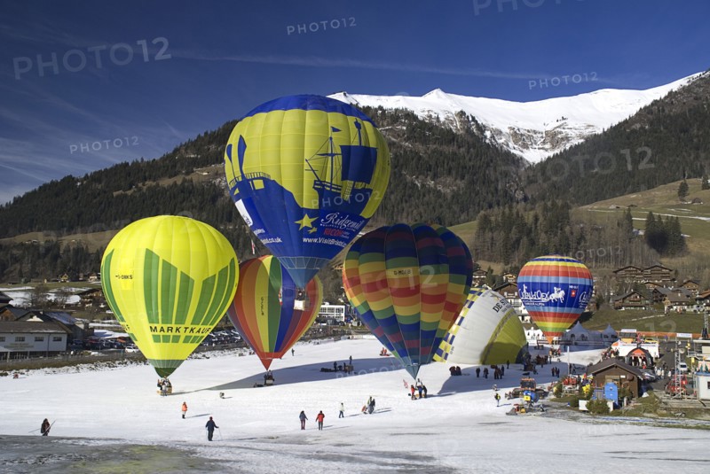 SWITZERLAND, Canton de Vaud, Chateau d'Oex, Hot Air Balloon taking off with others in preparation.