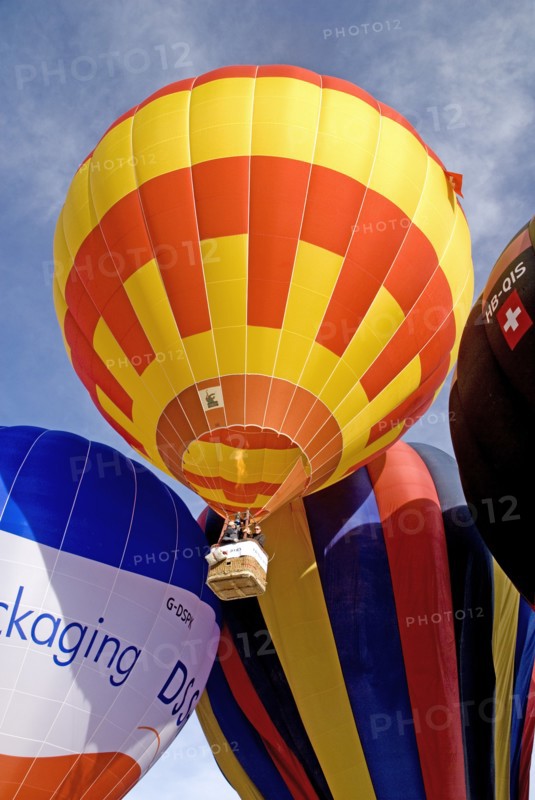 SWITZERLAND, Canton de Vaud, Chateau d'Oex, Hot Air Balloon taking off with people in basket visible.