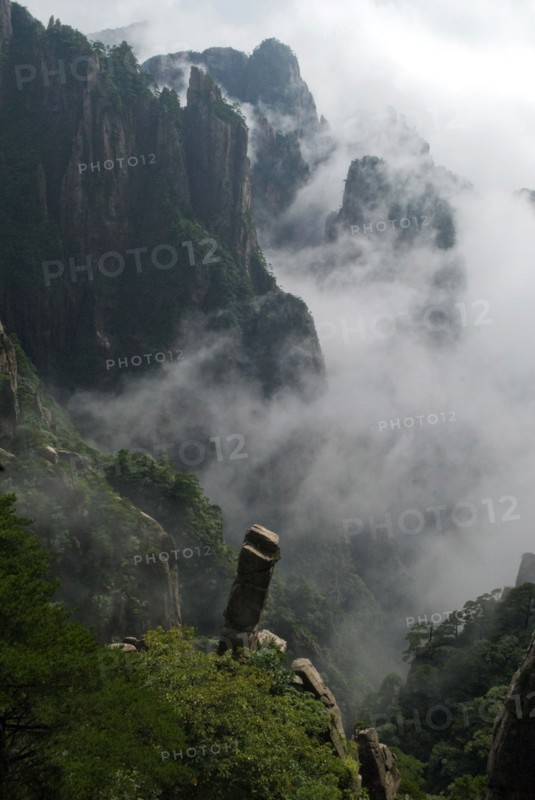CHINA, Anhui Province, Huang Shan , Huangshan or the Yellow Mountain. Rock peaks with lush green pine trees and a sea of cloud. Has inspired countlless painters and poets over the ages and has a 1200-year history as a tourist attraction