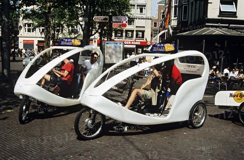 HOLLAND, Amsterdam , Wieler taxis and tourists waiting in a square