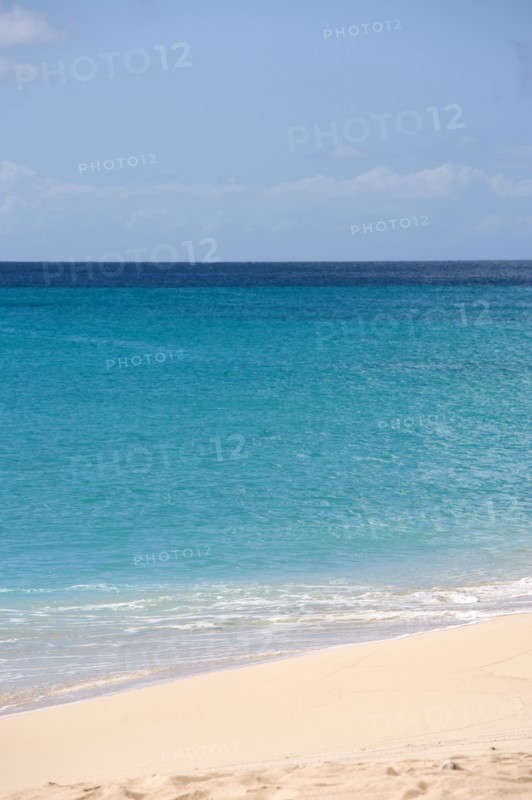 WEST INDIES, St Vincent And The Grenadines, Canouan Island, South Glossy Beach in Glossy Bay with waves breaking on the shoreline of the turqoise sea.