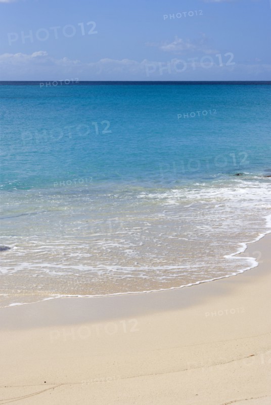 WEST INDIES, St Vincent And The Grenadines, Canouan Island, South Glossy Beach in Glossy Bay with waves breaking on the shoreline of the turqoise sea.
