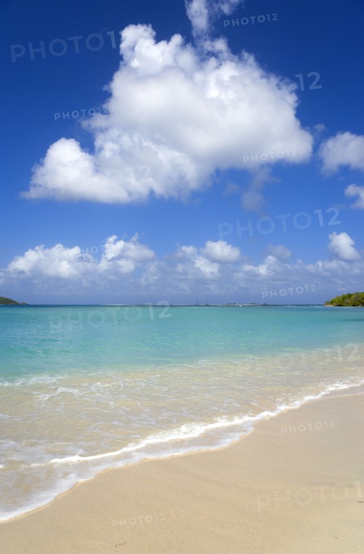WEST INDIES, Grenada, Carriacou, Waves breaking on Paradise Beach at L'Esterre Bay with the turqoise sea and Sandy Island sand bar beyond.