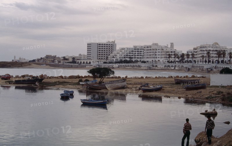 TUNISIA, Monastir, Hotels viewed from marina across beach and harbour.