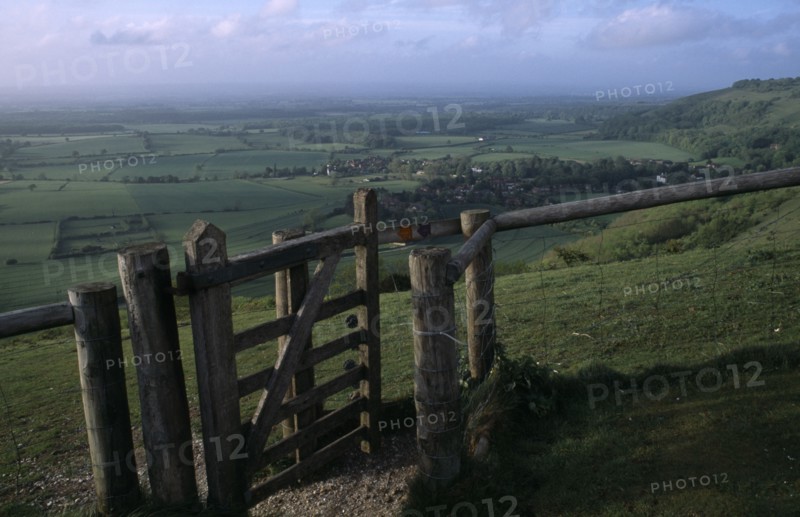 ENGLAND, West Sussex, Devils Dyke, Stile gate on Devil’s Dyke with view over lush green South Downs landscape
