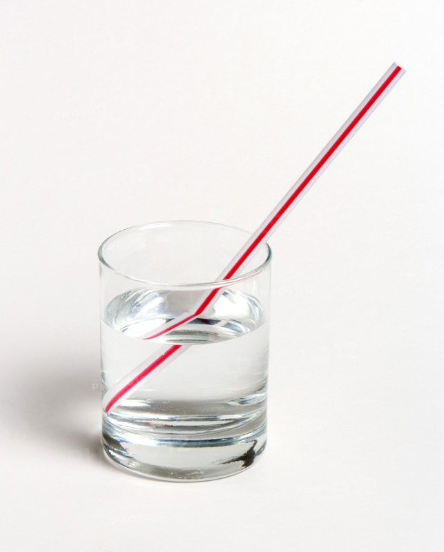 SCIENCE, Optics, Refraction, "A red and white straw in a glass of water on a white background. The straw appears to be broken, due to refraction of light as it emerges into the ai"