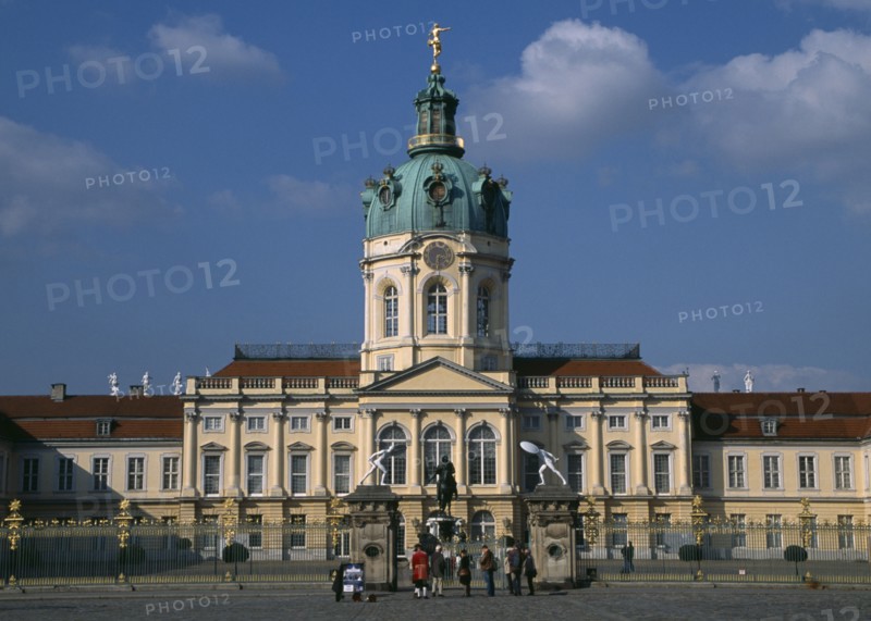 GERMANY, Berlin, Charlottenburg Palace.  Exterior facade of eighteenth century baroque palace with visitors outside ironwork gates.