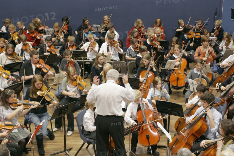 CHILDREN, Education, Music, Youth orchestra with conductor in foreground. Sir Michael Tippet giving a music workshop to some young musicians.