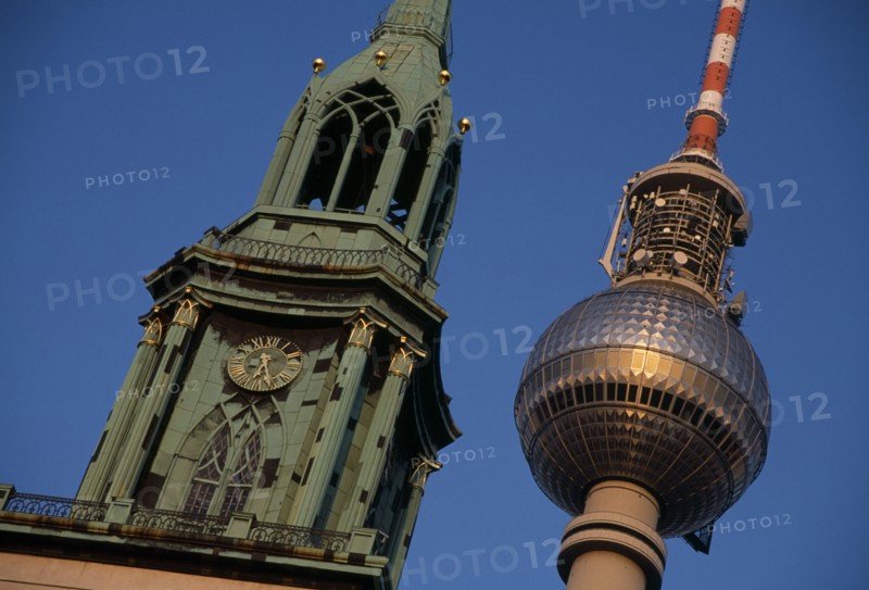 GERMANY, Berlin, Angled detail of the Fernsehturm or television tower beside clock and bell tower of historic St Mary s Church also called Marienkirche.