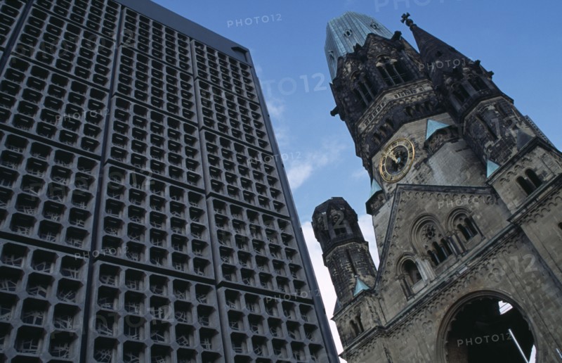 GERMANY, Berlin, Kaiser Wilhelm Memorial Church.  Part view of ruined gothic exterior with clock face beside new building.