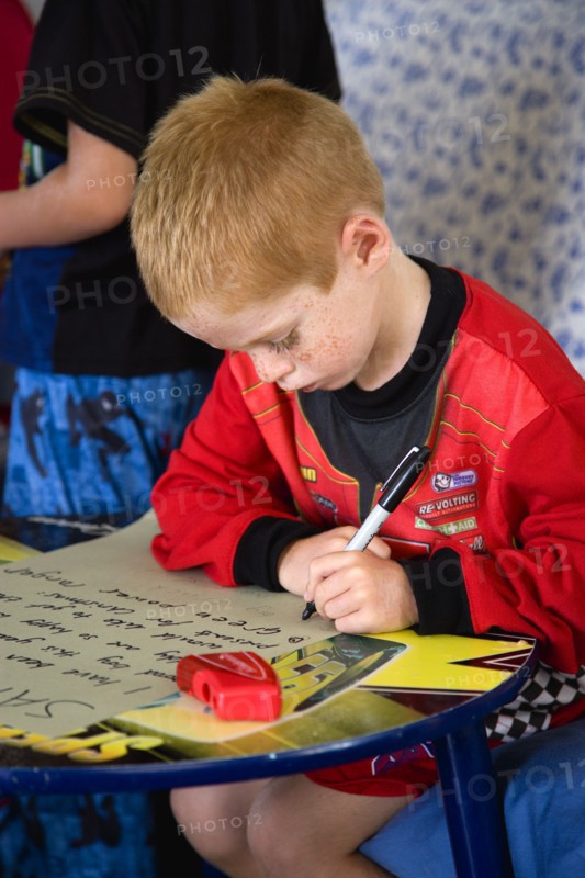 RELIGION, Festivals, Christmas, Young left handed boy at Christmas Eve sitting down and writing his Santa List at a table