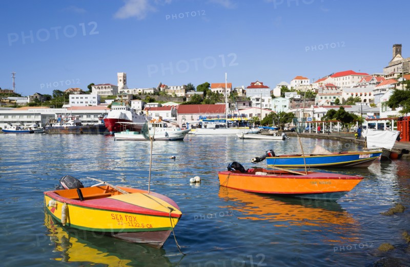 WEST INDIES, Grenada, St George, Water taxi boats moored in the Carenage harbour of the capital city of St George's with houses and the roofless cathedral damaged in Hurrican Ivan on the nearby hill