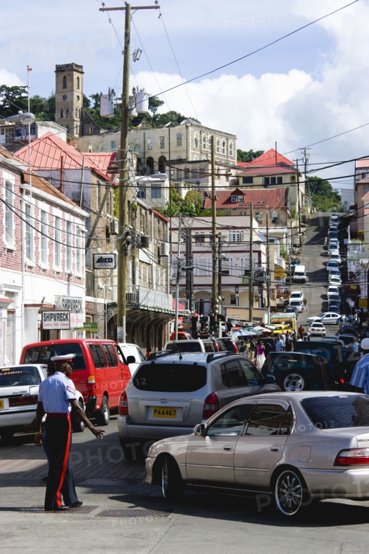 WEST INDIES, Grenada, St George, Male corporal of the Royal Grenadian Police Force directs traffic in busy Market Street in the capital city of St George's