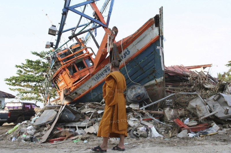 THAILAND, Phang Nga District, Nam Khem, "Tsunami. Monk looks at the damage caused by the tsunami, nothing is left standing in the village 2500 people are pressumed dead. 125kms north of Phuket on the 2nd Jan."