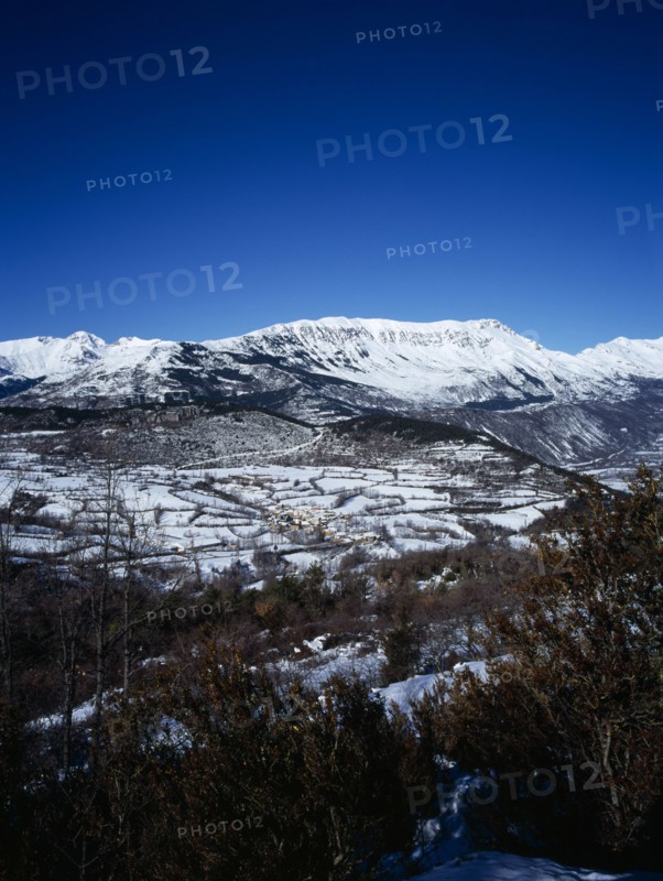 SPAIN, Aragon, Pyrenees, Snow covered mountain Macizo de Posets which is 3369 metres 11033 feet high point. The border with France on the right skyline. Trees in the foreground.