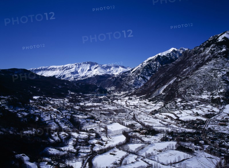 SPAIN, Aragon, Pyrenees, Elevated view south west along Rio Esera with snow covered valley and mountains. The town of Benasque seen on the lower right corner.