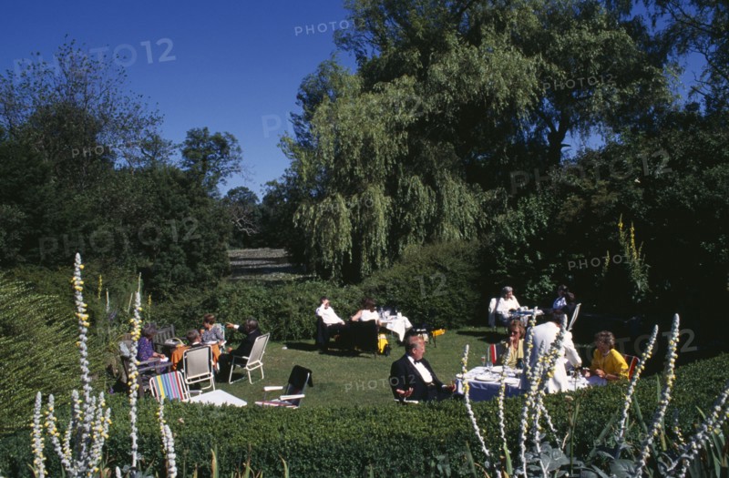 ENGLAND, East Sussex, Glyndebourne, Opera attendees enjoying picnics in the gardens during Opera interval.