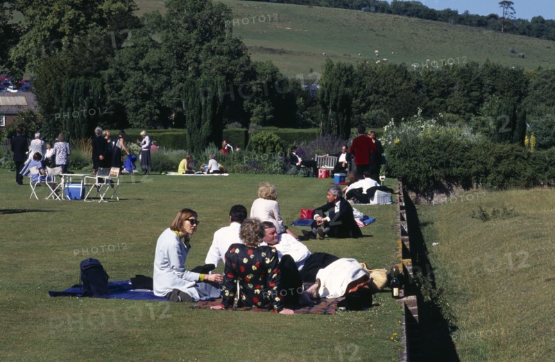 ENGLAND, East Sussex, Glyndebourne, Opera attendees enjoying picnics in the gardens during interval.