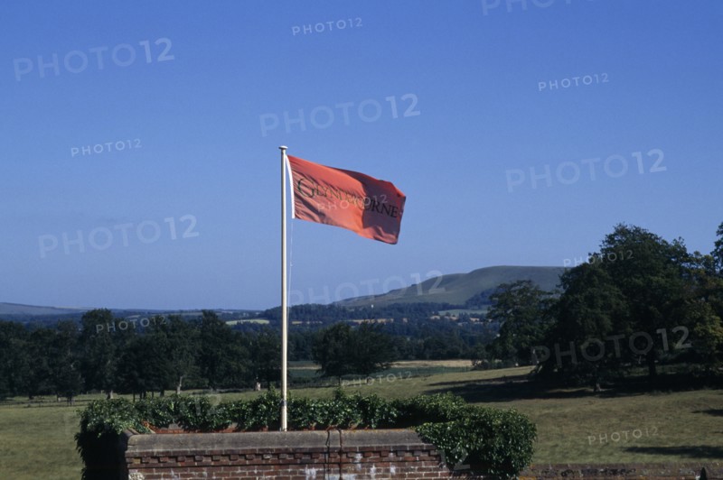 ENGLAND, East Sussex, Glyndebourne, Red flag in the grounds of the country house and opera house looking out over green countryside
