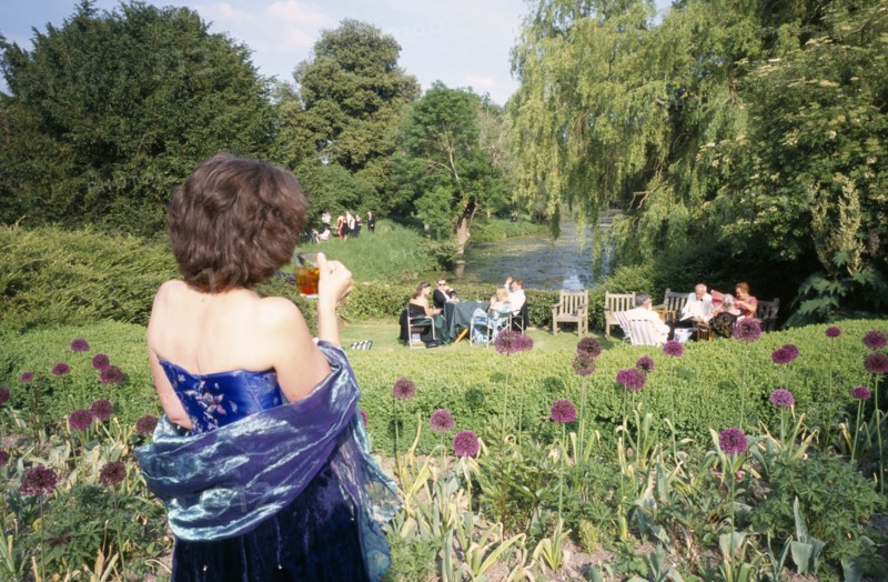 ENGLAND, East Sussex, Glyndebourne, Opera attendees enjoying picnics in the gardens during interval.