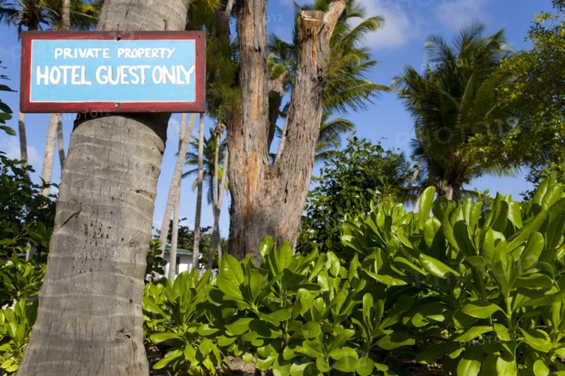 WEST INDIES, St Vincent & The Grenadines, Union Island, Sign attached to a coconut palm tree in the grounds of the Anchorage Yacht Club saying Private Property Hotel Guests Only.