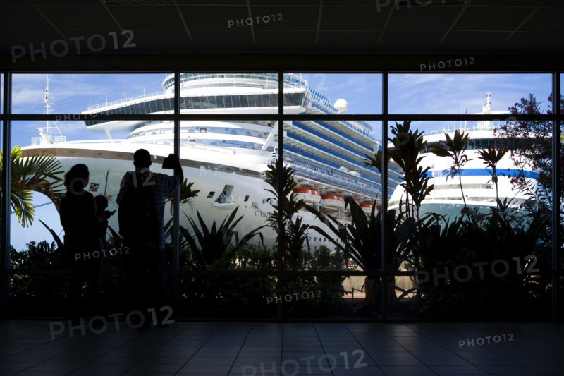 WEST INDIES, Grenada, St George, Tourists in the terminal building looking at the cruise ship liners Caribbean Princess and Aida Aura docked at the Cruise Ship Terminal in the capital St Georges.