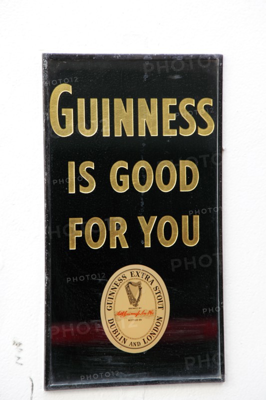 IRELAND, North, Belfast, "Cathedral Quarter, Commerical Court, Old metal Guinness sign decorating the exterior of the Duke of York Public House."