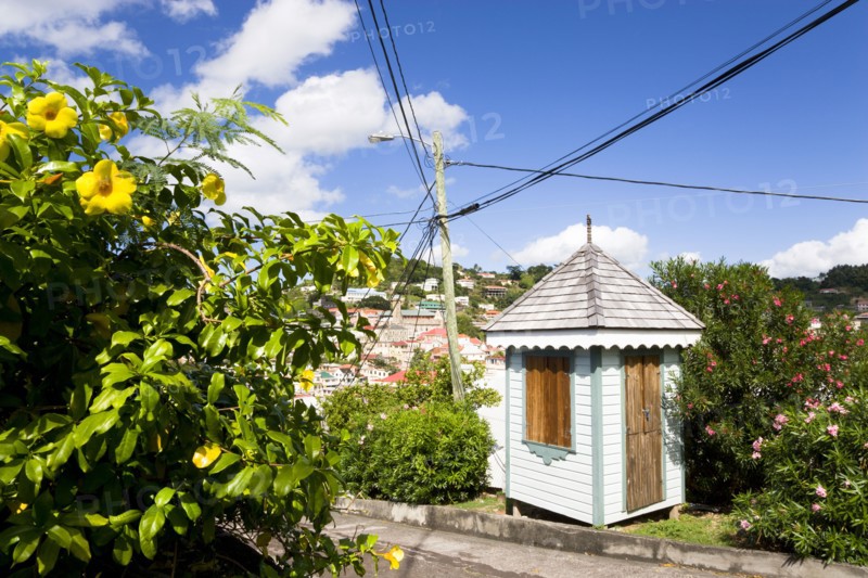WEST INDIES, Grenada, St George, Colourful sentry post set amongst flowering plants on the road up from the capital to Fort George overlooking the capital.