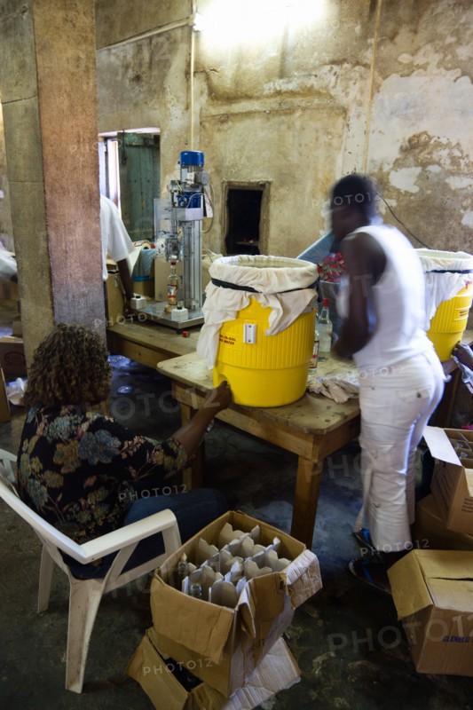 WEST INDIES, Grenada, St Patrick, Female workers hand bottling the rum at the River Antoine distillery.