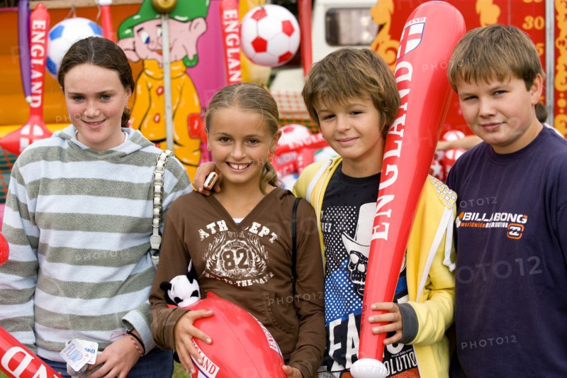 ENGLAND, West Sussex, Findon, Findon village Sheep Fair Two teenage boys and two girls holding prizes won at fairground stalls.