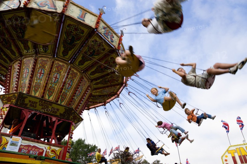 ENGLAND, West Sussex, Findon, Findon village Sheep Fair Children in motion riding on a swing carousel.