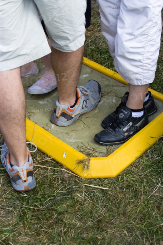 ENGLAND, West Sussex, Findon, Findon village Sheep Fair People walking through a foot bath at a Bio Security Point to help prevent spread of foot and mouth disease.