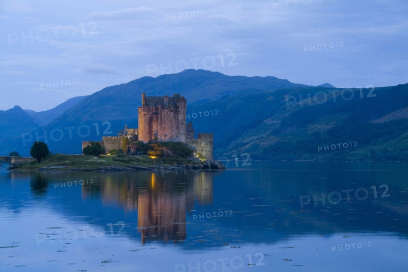 SCOTLAND, Highlands, Dornie, "Eilean Donan Castle in Loch Duich, the most photographed castle in the world at night with reflection on still waters."