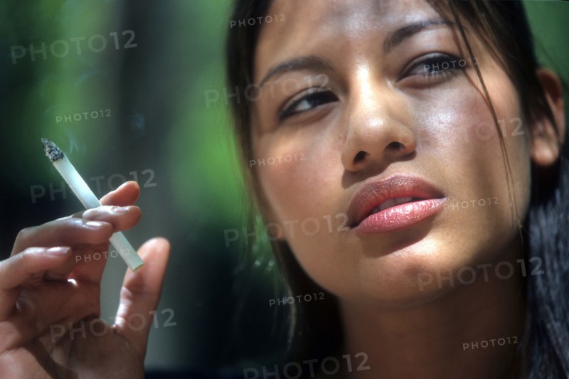 MEDICAL, Health, Smoking, Head shot of young Latino woman smoking cigarette.