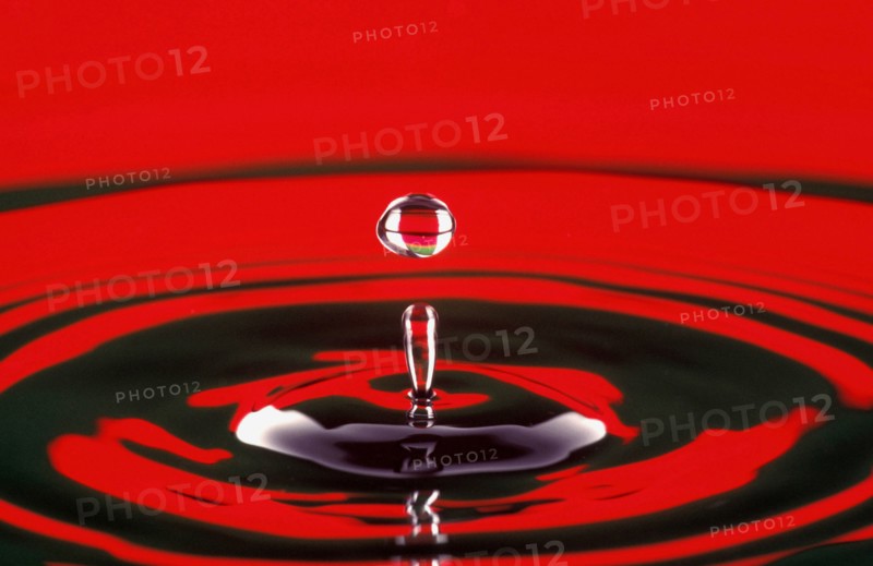 WATER, Droplet, Water drop at moment of suspension and circular ripple effect below.  Bright red reflected colour.