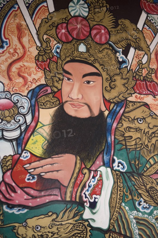 THAILAND, North, Chiang Mai, Pung Tao Gong Ancestral Temple. Close up of a colourful mural depicting a male deity.