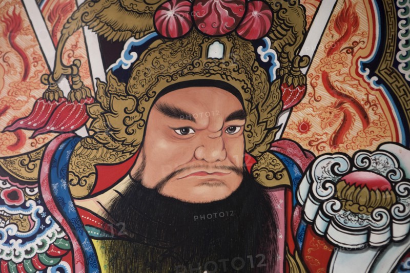 THAILAND, North, Chiang Mai, Pung Tao Gong Ancestral Temple. Close up of a colourful mural depicting a male deity.