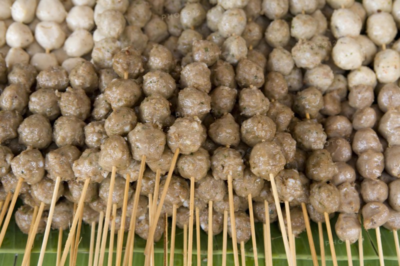 THAILAND, North, Chiang Mai, Close up of pork meat balls on wooden skewers in the market.
