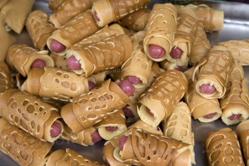 THAILAND, North, Chiang Mai, Close of small sausages wrapped in pancakes on sale in market. Pigs in blankets.